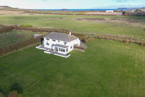 Ariel view of Booby's Bay Cottage with coastal views and large grassed garden