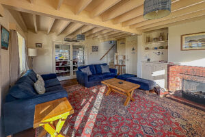 Lounge with fire place and stairs leading to first floor at Booby's Bay Cottage