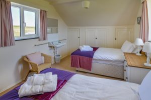 Twin single bedroom with a sink and storage at Booby's Bay Cottage
