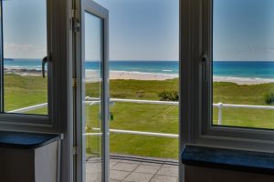 Doors to roof terrace from Bedroom 2 with views across the beach at Booby's Bay Cottage