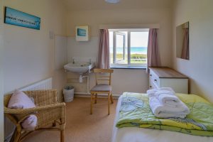 Single bedroom with a sink and chairs at Booby's Bay Cottage