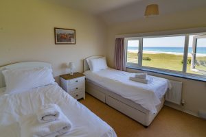 Twin single beds with sea views at Booby's Bay Cottage