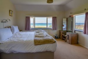 Superking ensuite bedroom with sea views at Booby's Bay Cottage