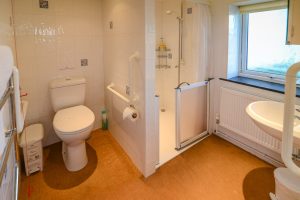 Ensuite bathroom with walk in shower, loo and sink at Booby's Bay Cottage