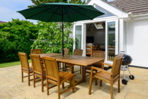 Seating area with BBQ and parasol at exterior of Beachcombers
