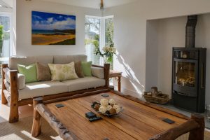 Lounge at Beachcombers with large coffee table and log burner