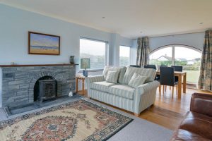 Lounge with log burner and dining area at Bosporthennis