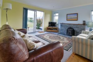 Lounge at Bosporthennis with seating, log burner and TV