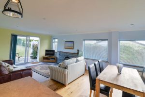 Lounge and dining area with doors leading to patio at Bosporthennis