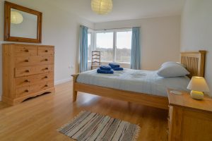 King ensuite bedroom with storage and large window at Cheyney