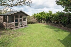 Grassed garden area at Cobs with summer house