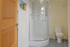 Ensuite from the twin bedroom with shower cubicle, toilet and basin at Cobs