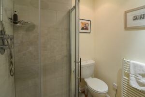 Bathroom with toilet and walk in shower at Curlews