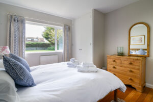King sized bedroom with storage and large mirror at Curlews