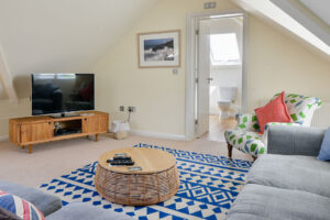 First floor lounge area with TV and a door leading to upstairs bathroom