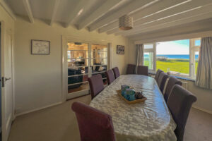 Dining room at Booby's Bay Cottage, seating for ten and sea views