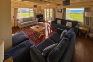 Lounge with ample seating, TV and sea views at Booby's Bay Cottage