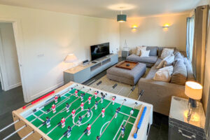 Small lounge at Cheyney with corner sofa, games and large TV