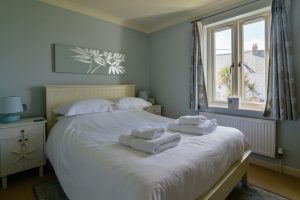 Master double bedroom and window with sea views at Apartment 5 Greenwaves