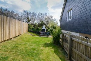 BBQ and bench in grassed garden area at Aquataine Annexe