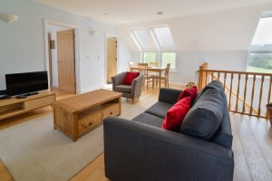 Open plan lounge/sofa bed and dining area with TV at Aquataine Annexe