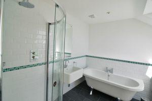 Main bathroom with bath and shower at Aquataine Annexe