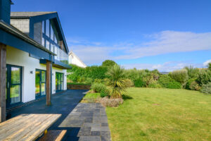 Rear exterior at Blue Seas with large grassed garden and patio