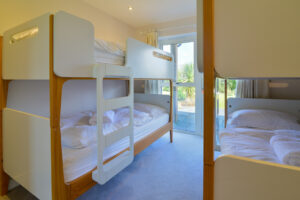 Two single bunk beds on ground floor with patio doors at Blue Seas