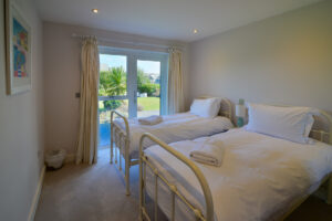 Twin ensuite ground floor bedroom with patio doors at Blue Seas