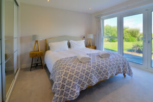 Superking ensuite bedroom with doors to patio at Blue Seas