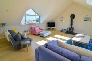 Lounge area with ample seating, TV and log burner at Blue Seas
