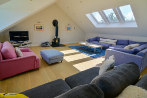 Lounge at Blue Seas, with ample seating, TV and log burner