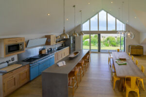 Open plan kitchen and dining area with ample seating and balcony at Blue Seas