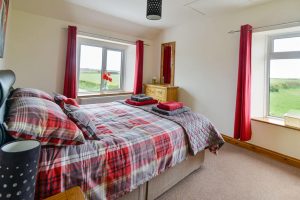 King sized bedroom with rural views from windows at Carnavis Cottage