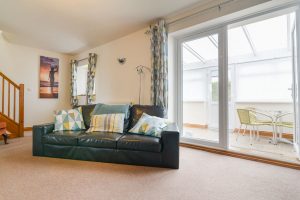 Lounge with doors to sun room at carnavis Cottage
