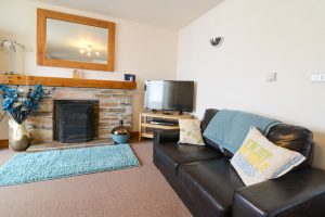 Lounge with TV and gas fired log burner at Carnavis Cottage