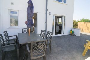 Patio area with outdoor seating and parasol at Carnavis Cottage