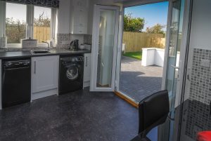Double doors to patio and rear garden in kitchen at Carnavis Cottage