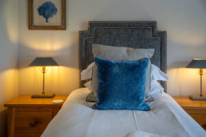 Bed in twin room with bedside tables and lamps at Penjerrick