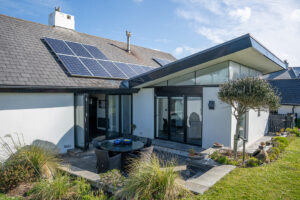 Rear exterior of Morvoren with grassed garden area and patio with seating
