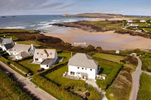 Aerial view over South Corner and Treyarnon beach with view towards Trevose Head and the ocean