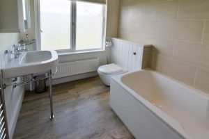 Main family bathroom with sink, loo and bath with overhead shower at Gortheren