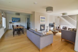 Herongate dining and lounge area showing dining table, wood burner and ample seating