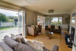 Lounge area at Herongate with wood burner, bifold doors to both patio and conservatory