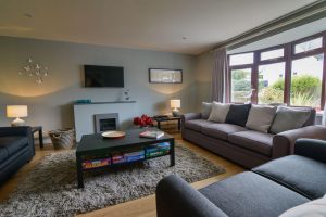 Lounge at High Tides with ample seating, mounted TV and gas fire
