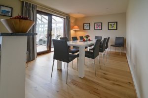 Dining area for 10 with doors leading to conservatory at High Tides