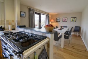 Dining area off of kitchen, with double doors leading to conservatory at High Tides