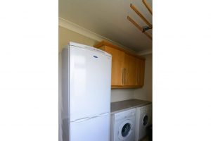 Utility room at High Tides with fridge/freezer, washer and dryer