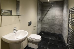 Ground floor bathroom with walk in shower, wash basind and toilet at High Tides