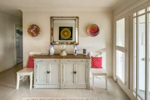 Entrance hallway with wooden painted flooring, storage cupboard and ornaments at Penamont